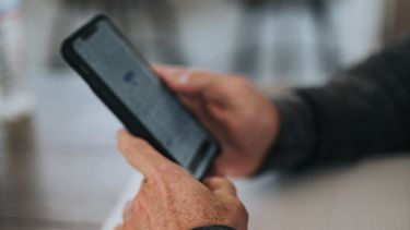 A close up of a person's hands holding a phone